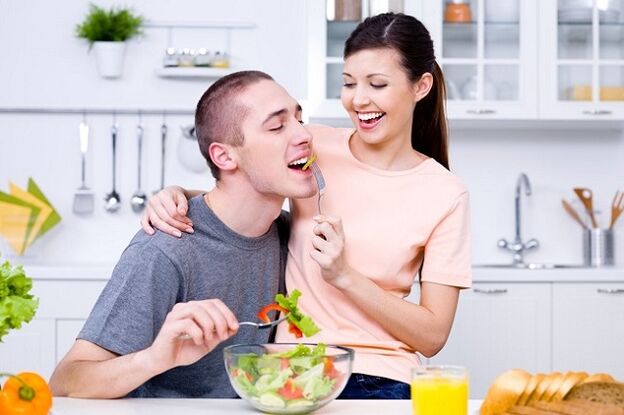 dívka krmí muže vitamínovým salátem na potenciál